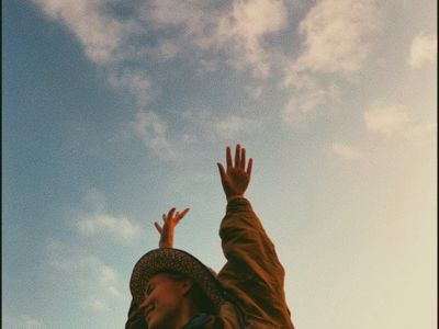 Woman stretching her arms towards the sky